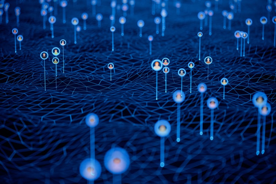 An image of a network of blue position pins on a 3D polygonal terrain, each pin with an image of a person inside it.